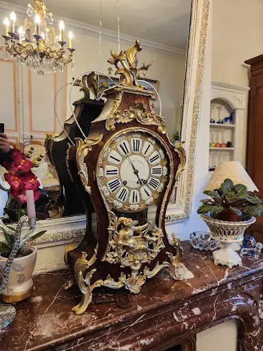 Horloge de table ancienne ornee de bronze dore sur un meuble en marbre